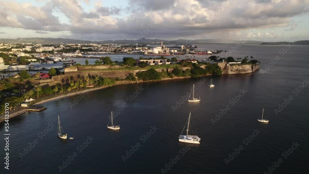 Waterfront with sailboats and historic French fort in Martinique.