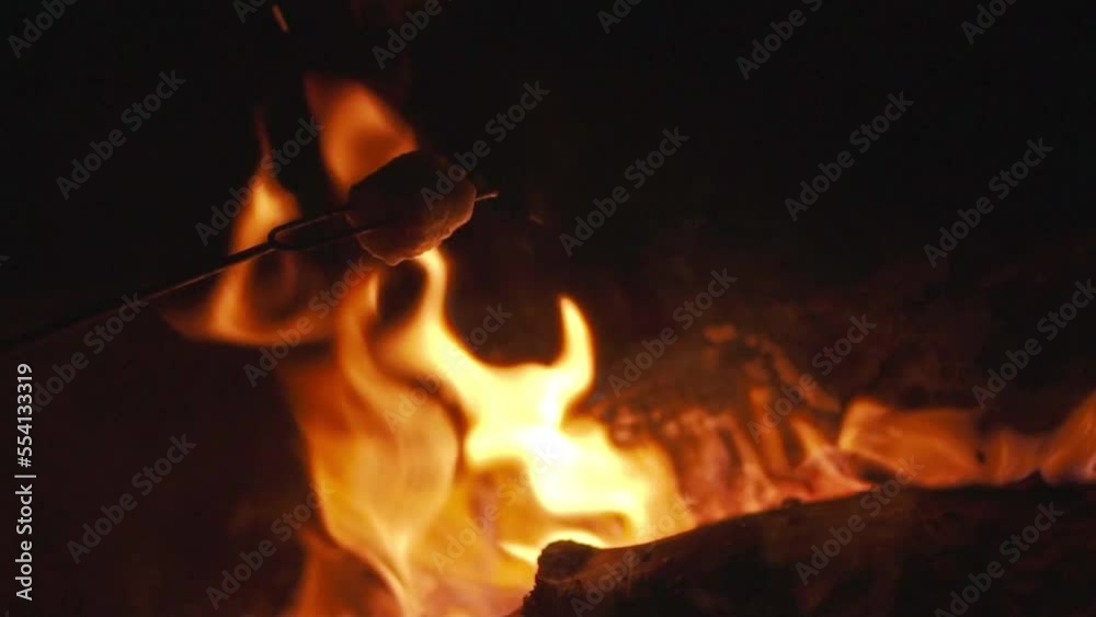 Closeup Shot of Roasting a Marshmallow Over a Campfire, Slow Motion Closeup Shot of Roasting a Marshmallow Over a Campfire, Slow Motion