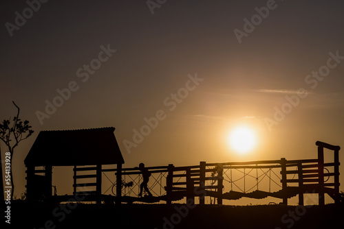 Silhouette of a kid playing on a playground at sunset time at Ecopark (Ecoparque) in Caxias do Sul, Rio Grande do Sul, Brazil