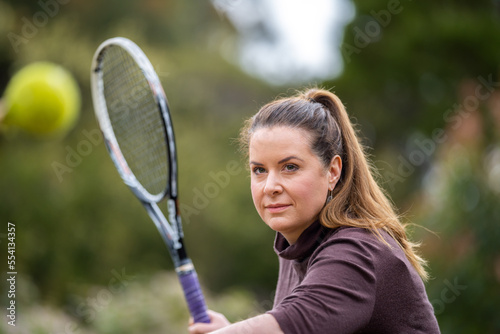 female athlete hitting tennis balls. woman playing social tennis © Phoebe
