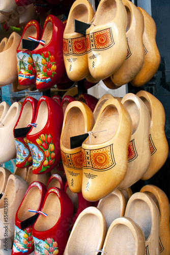 Traditional wooden Dutch farmers shoes - clogs, klomps. Hang on a rack.  Popular souvenirs. Traditions of Holland. Old costume of The Netherlands.