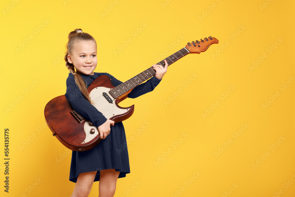 Happy girl with electric guitar on yellow background. Space for text Happy girl with electric guitar on yellow background. Space for text