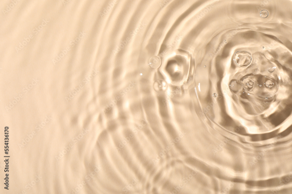 Closeup view of water with rippled surface on beige background