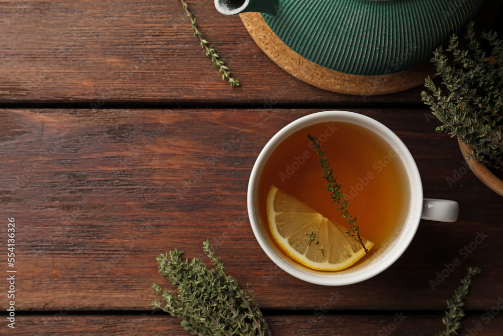 Aromatic herbal tea with thyme and lemon on wooden table, flat lay. Space for text