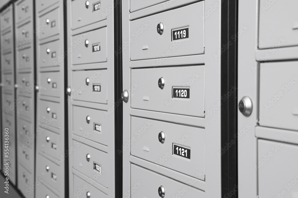 Closed metal mailboxes with keyholes and sequence numbers indoors Closed metal mailboxes with keyholes and sequence numbers indoors