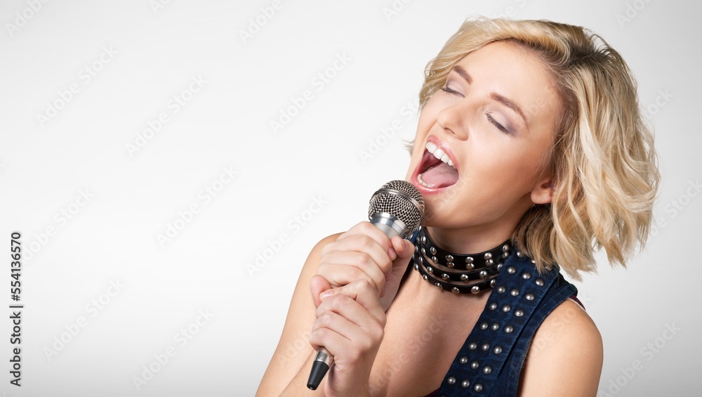 Happy young girl singing and holding microphone Happy young girl singing and holding microphone
