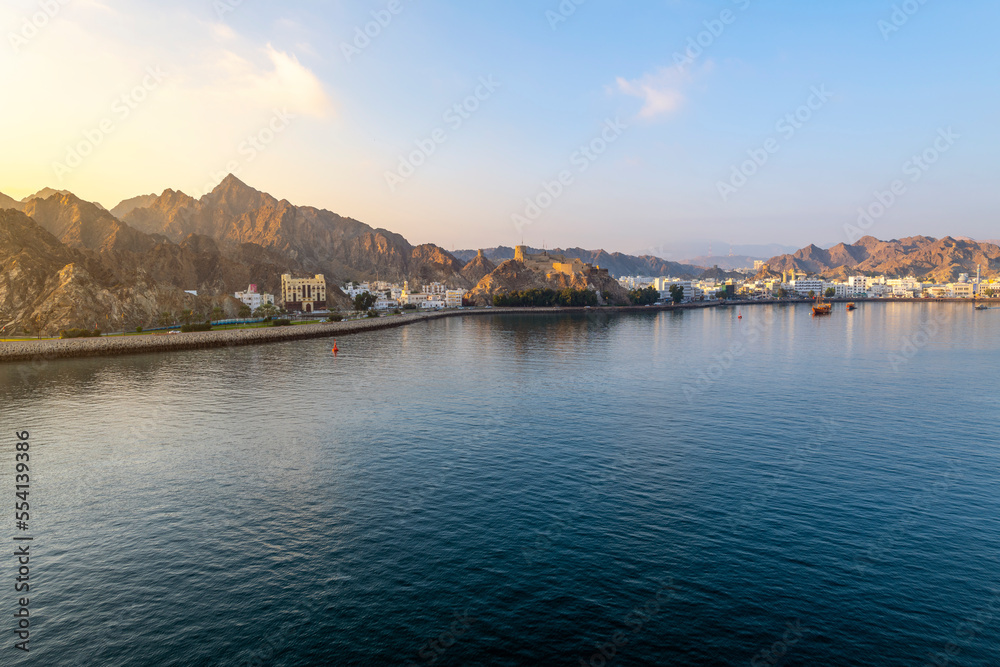 Early morning view from the sea of the old city, Mutrah Fort and Mutrah Corniche waterfront at the Port Sultan Qaboos of Muscat Oman along the Gulf of Oman in the Arabian Sea  