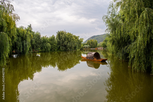 Traditional Chinese boat on a calm lake during the sunset, Kunming, China