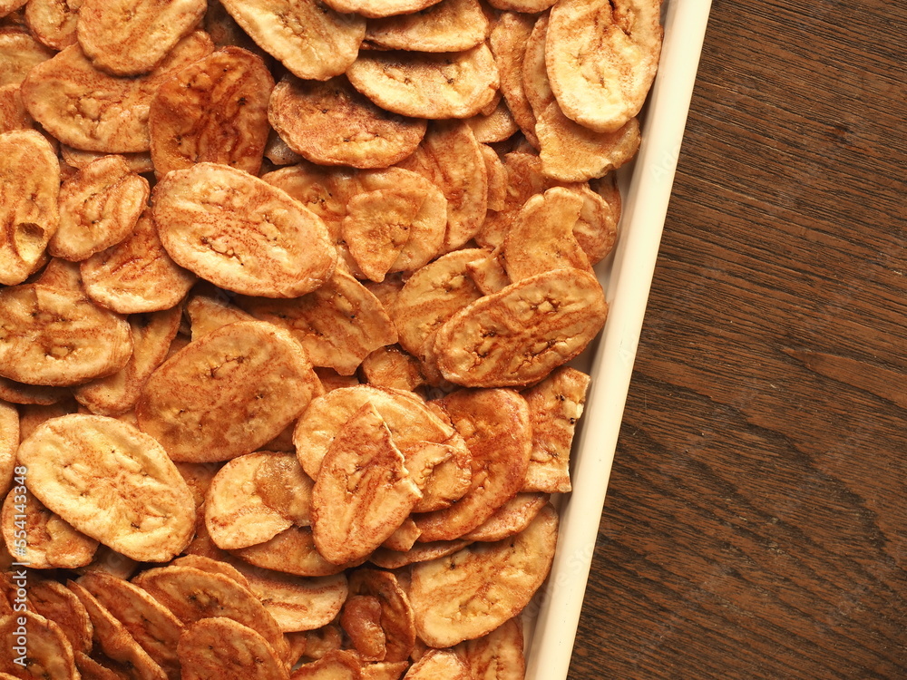 Top view banana chips on wooden background Top view banana chips on wooden background