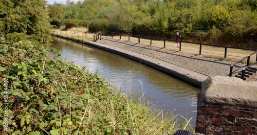 Wide shot from Aston Lock looking down on to Trent and Mersey Canal with man running through the shot. photo