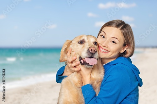 Happy young woman play with a dog on outdoors