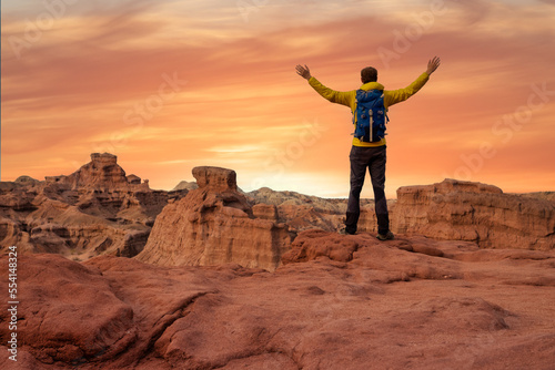 Hiker open arms at mountain peak reaching life goal, freedom, success and happiness, achievement in mountains at sunset in Cafayate, Salta, Argentina - Adventure travel concept photo