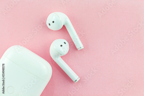 Wireless headphones or Bluetooth headphones on a pink background.