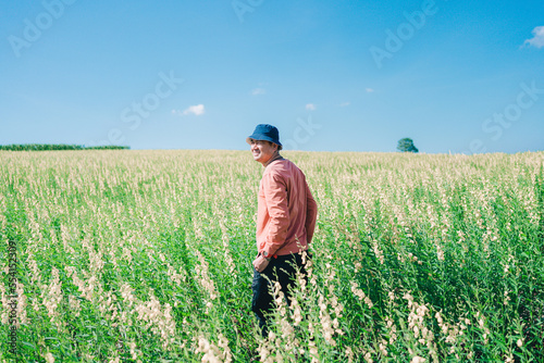 Portrait Asian man standing looking goal in jute field. Yellow flower field at spring. © 2p2play