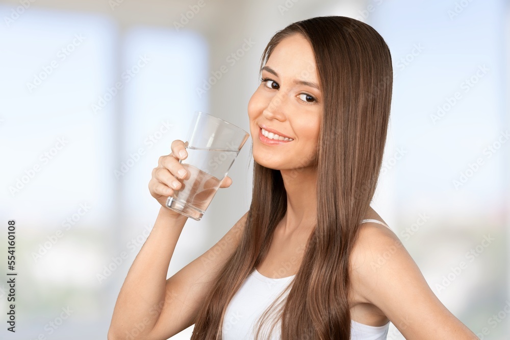 Happy young woman smiling and drinking water Happy young woman smiling and drinking water