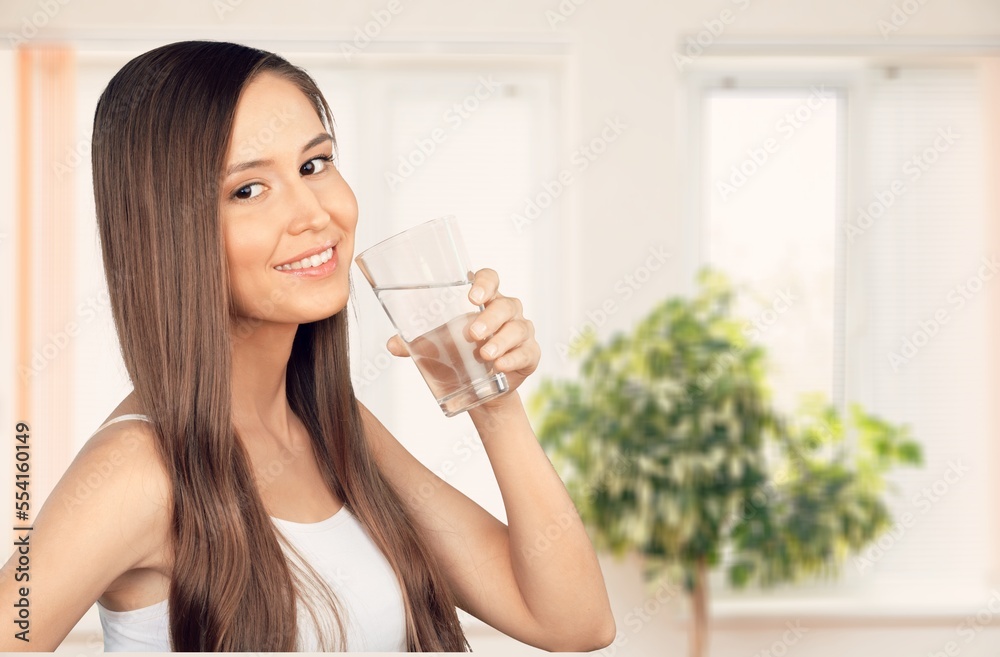 Happy young woman smiling and drinking water Happy young woman smiling and drinking water