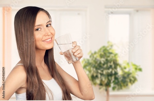 Happy young woman smiling and drinking water