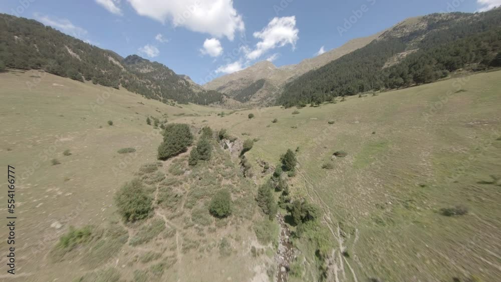 Cinematic aerial view across lush Esterri D'aneu freen rock mountain valley gorge, Catalonia, Spain Cinematic aerial view across lush Esterri D'aneu freen rock mountain valley gorge, Catalonia, Spain