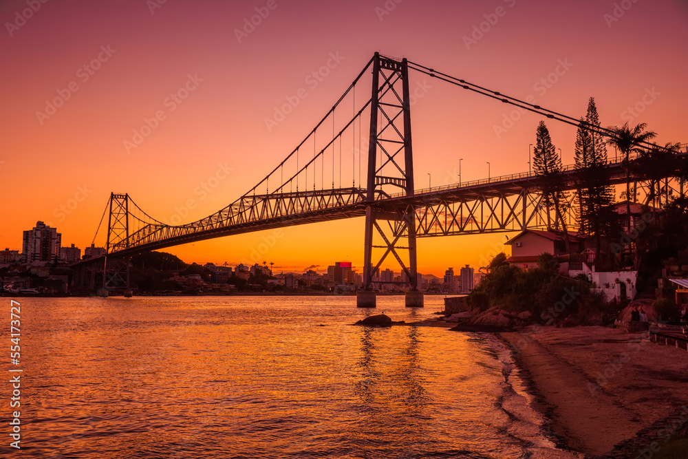 Hercilio luz cable bridge with sunset and reflection on water in Florianopolis