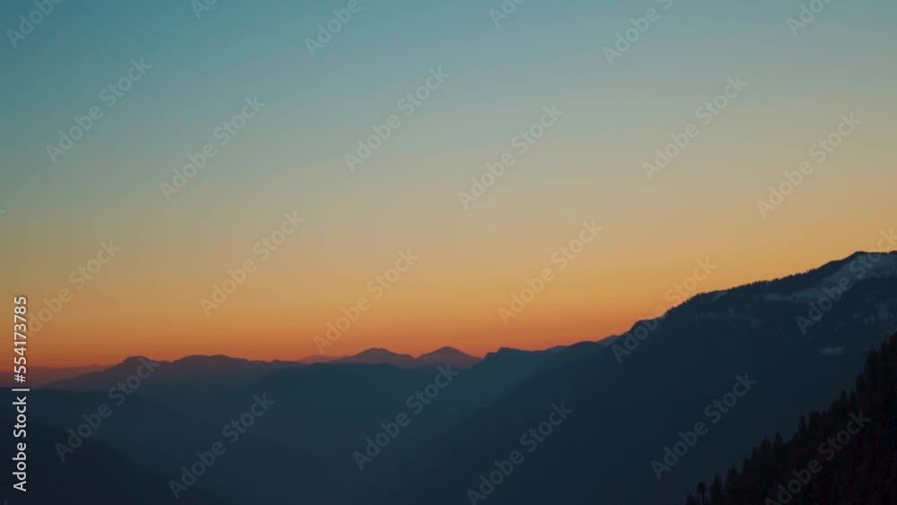 Silhouette shot of foggy mountain layers of the Himalayan mountain range during the sunset at Manali in Himachal Pradesh, India. View of the mountain ranges as seen from the top of mountain at sunset.