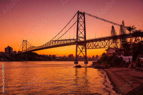 Hercilio luz cable bridge with sunset and reflection on water in Florianopolis