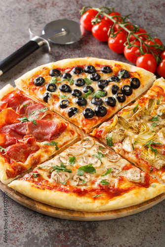 Italian pizza four seasons or quattro stagioni include combination of tomatoes, mozzarella, mushrooms, artichokes, ham, and olives closeup on the table. Vertical photo
