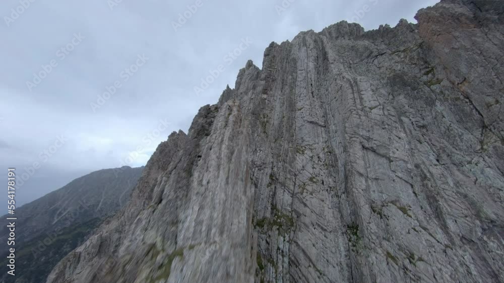 FPV aerial view rising up Esterri D'aneu sharp rocky mountain ridges towards summit, Catalonia, Spain