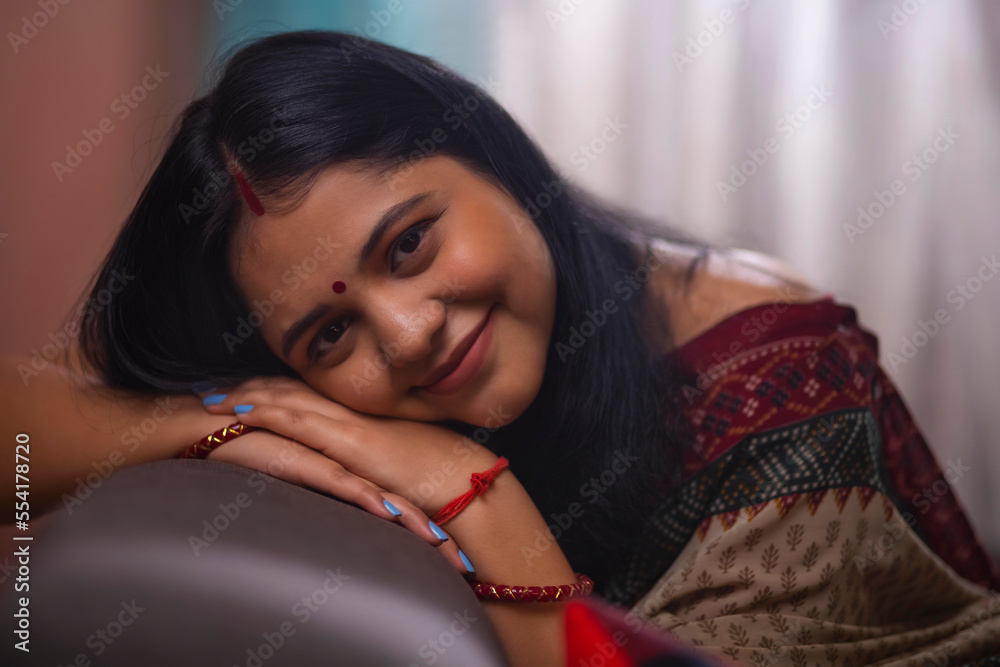Close-up portrait of a happy married woman leaning on sofa and looking at camera at home Close-up portrait of a happy married woman leaning on sofa and looking at camera at home