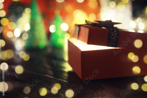 Gift boxes against a background bokeh of twinkling party lights. Luxury New Year gift. Christmas gift. Christmas background with gift box. Christmastime celebration © alexkich