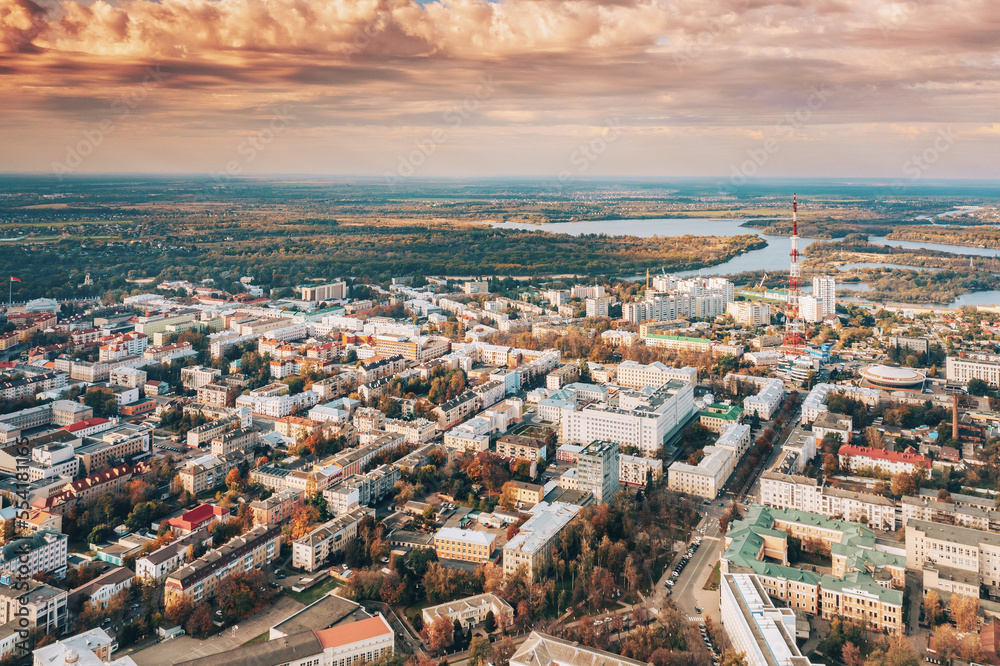 Aerial view of Homiel cityscape skyline in autumn sunny day. Bird's-eye view of Gomel TV tower, circus building, residential district and river in autumn sunny day. Dramatic sky over residential