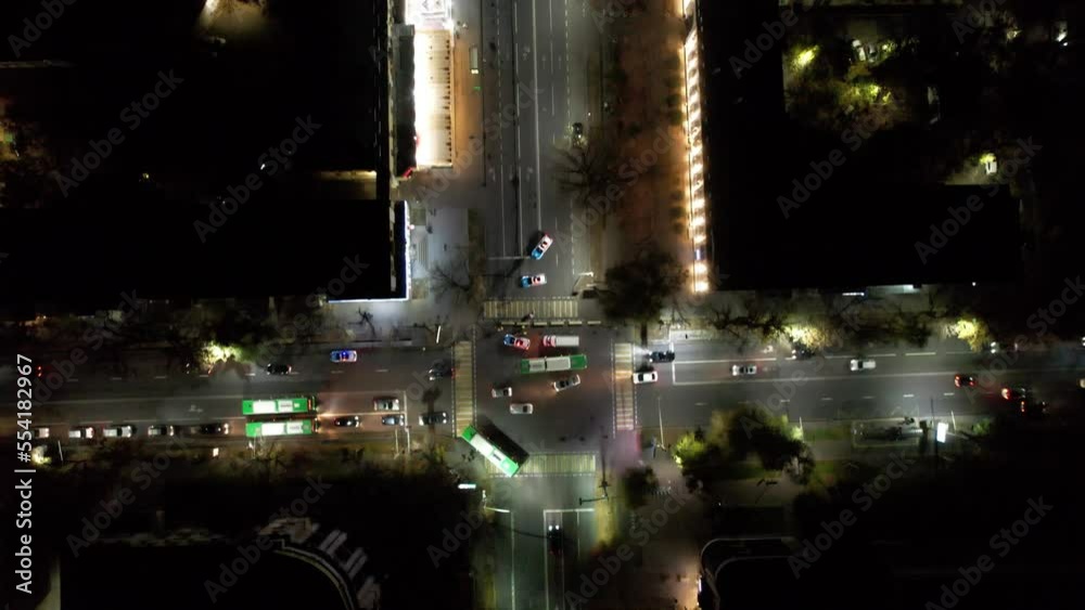 Aerial view from a drone at a night intersection. Small traffic from cars and buses is moving along the road. The passage is blocked by police cars with flashing lights. A concert is taking place Aerial view from a drone at a night intersection. Small traffic from cars and buses is moving along the road. The passage is blocked by police cars with flashing lights. A concert is taking place