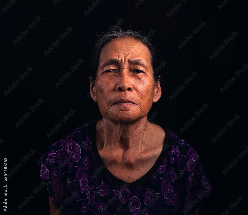 Portrait of an Asian elderly woman wearing short sleeves on a black background. Portrait of an Asian elderly woman wearing short sleeves on a black background.