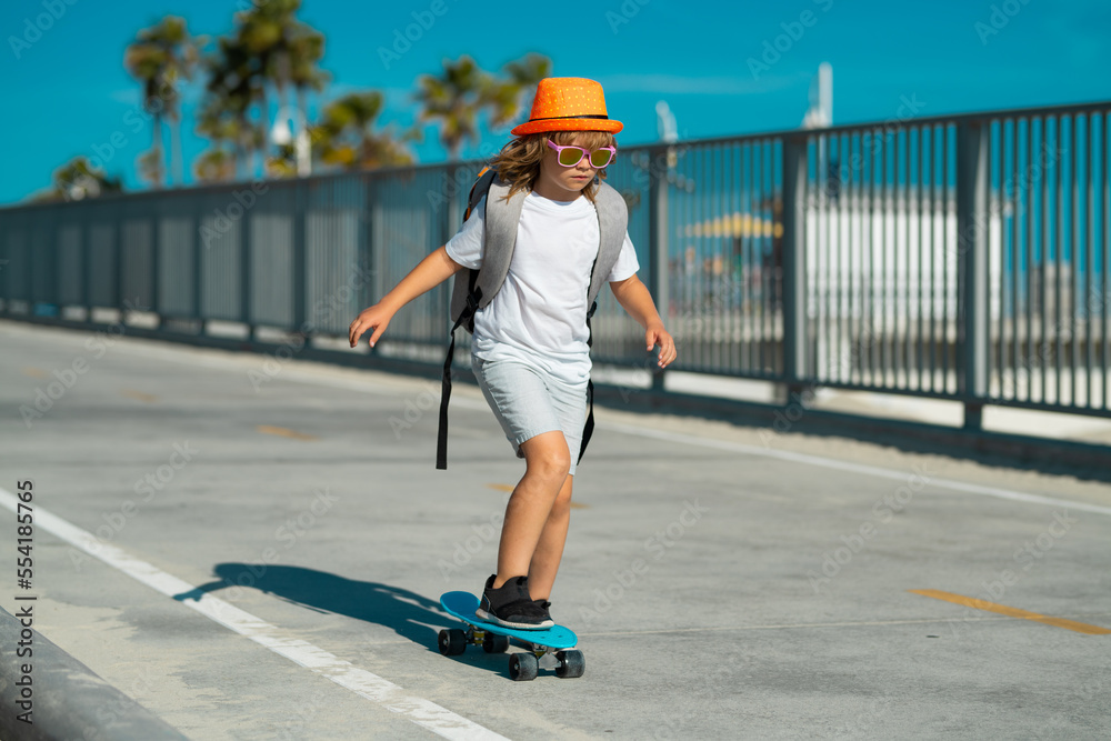 Child riding skateboard in summer park. Little boy learning to ride skate board. Active outdoor sport for kids. Children skateboarding. Kid ride on skateboard. Lets ride. Child on skateboard skating. Child riding skateboard in summer park. Little boy learning to ride skate board. Active outdoor sport for kids. Children skateboarding. Kid ride on skateboard. Lets ride. Child on skateboard skating.