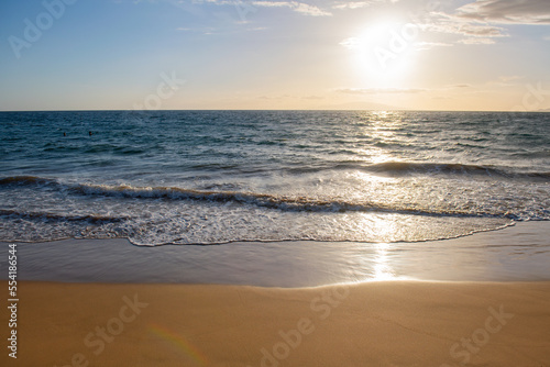 Sunset. Blue ocean wave on sandy beach. Beach in sunset summer time. Beach landscape. Tropical seascape, calmness, tranquil relaxing sunlight.