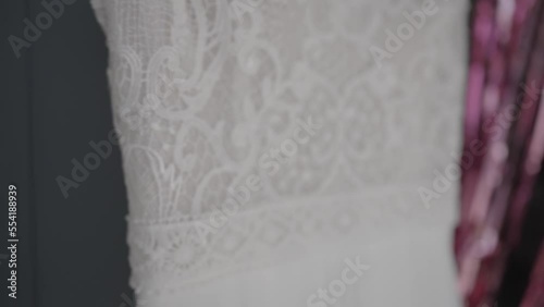 close-up video shooting of beautiful lace patterns on a wedding dress that hangs on a coat hanger
