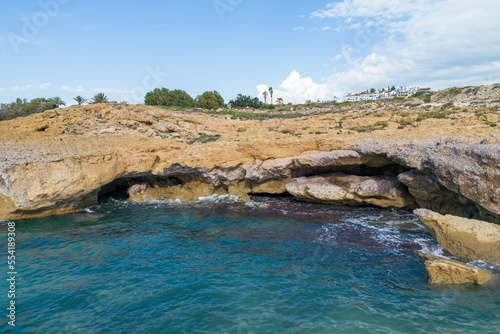 Sea caves on the rocky coast of Cyprus. Rocky shore broken by waves.