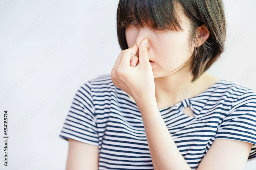 Woman showing dislike of bad smell by covering her nose. Woman showing dislike of bad smell by covering her nose.