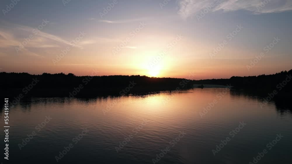 Aerial view of orange river surface at sunset and silhouettes of vacationers on the shore and swimming Aerial view of orange river surface at sunset and silhouettes of vacationers on the shore and swimming