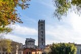 downtown Lucca in Tuscany framed by autumn foliage with a view of the San Frediano Basilica