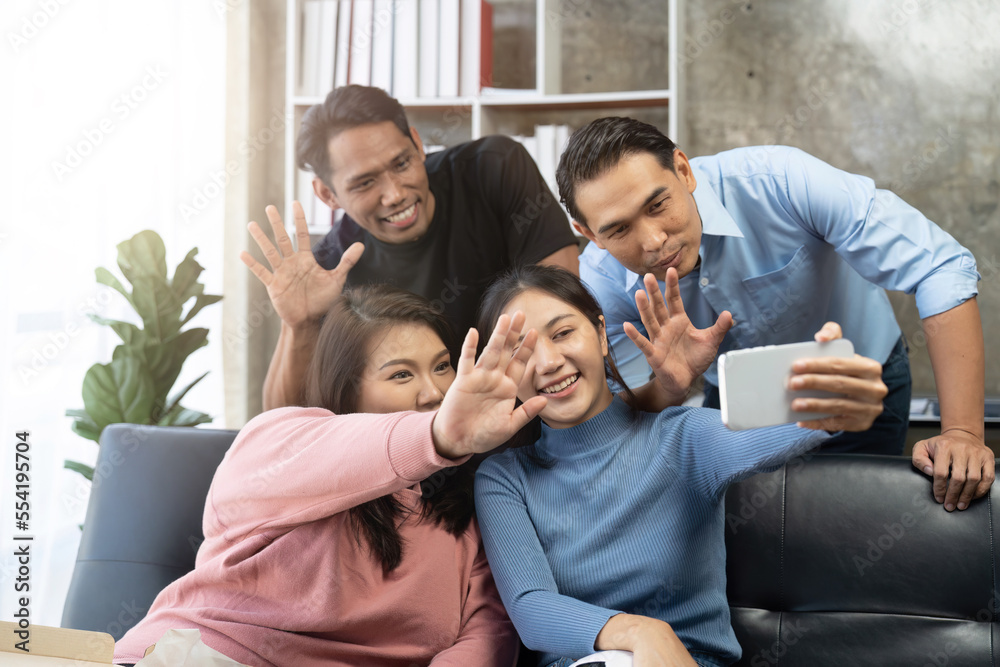 Fototapeta premium Friends watch sports on TV, cheer and celebrate. Happy diverse asian friend supporters fans sit on couch with popcorn and drinks
