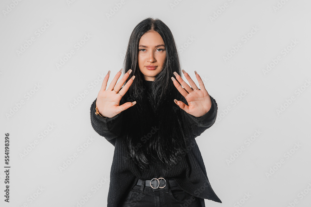 Stop it. Young woman making stop sign with hands, saying no, looking at camera, stands over white background. Serious girl with long hair disapprove smth, prohibit, taboo gesture Stop it. Young woman making stop sign with hands, saying no, looking at camera, stands over white background. Serious girl with long hair disapprove smth, prohibit, taboo gesture