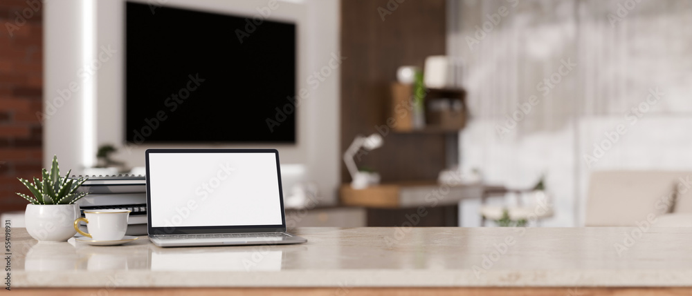Obraz premium Laptop mockup and copy space on white marble tabletop against blurred background of living room