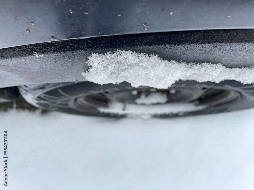 Top view on the winter tire of a car in the middle of the winter with cold temperatures and a lot of snow and ice as a symbol for traffic in the winter Top view on the winter tire of a car in the middle of the winter with cold temperatures and a lot of snow and ice as a symbol for traffic in the winter