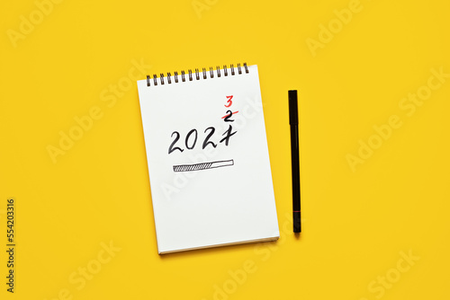 New year resolution, Goals setting for the 2023 year, text 2023 loading in open notepad on yellow desk background. Start new life, planning and setting goals