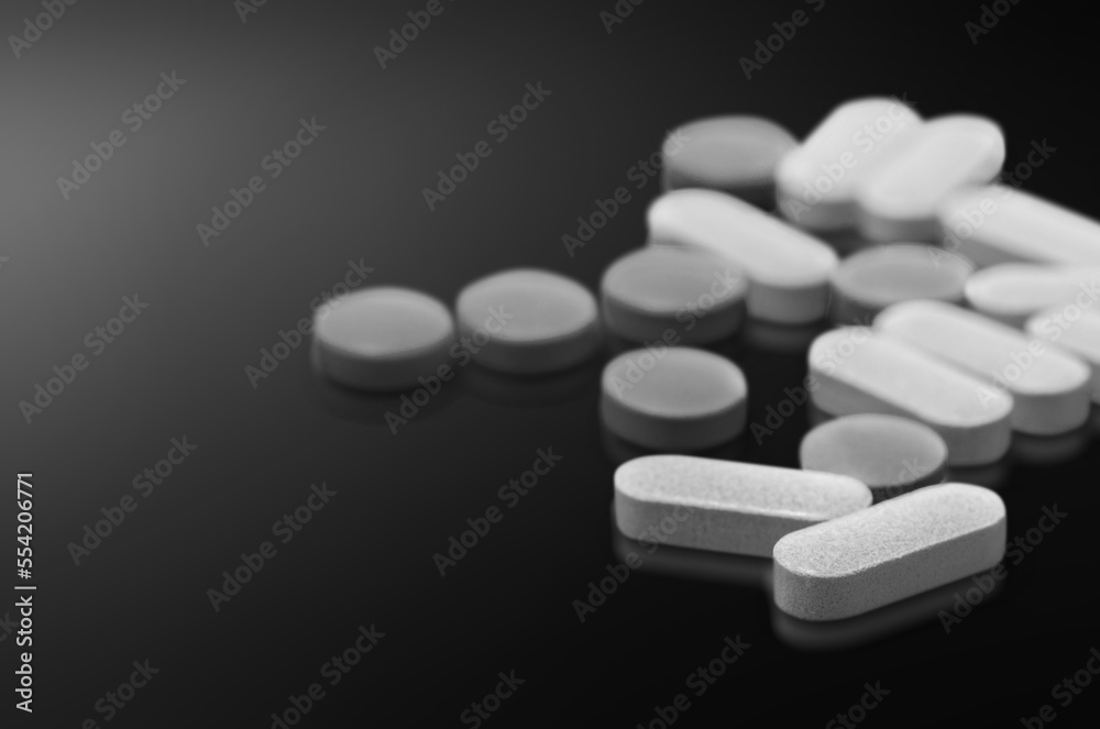 Supplements, pills, drugs on dark background.