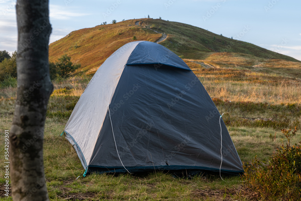 grey tent on the lawn overlooking the mountain in the setting sun