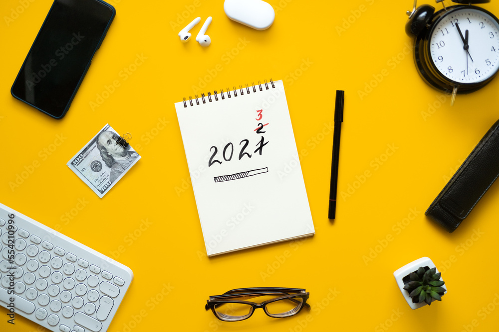 New year resolution, Goals setting for the 2023 year, text 2023 loading in open notepad on yellow desk background. Start new life, planning and setting goals New year resolution, Goals setting for the 2023 year, text 2023 loading in open notepad on yellow desk background. Start new life, planning and setting goals