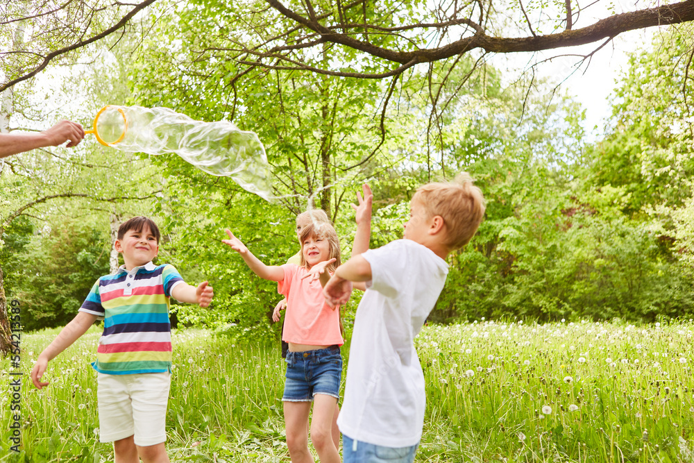 Children enjoying while playing with soap bubble Children enjoying while playing with soap bubble