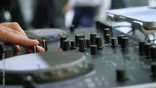 Close-up of man playing on dj console. Media. Man turns buttons on music console. DJ plays new music console at disco