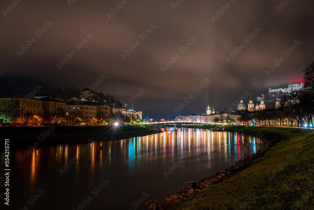 Night view of Salzburg across River Salzach, Austria